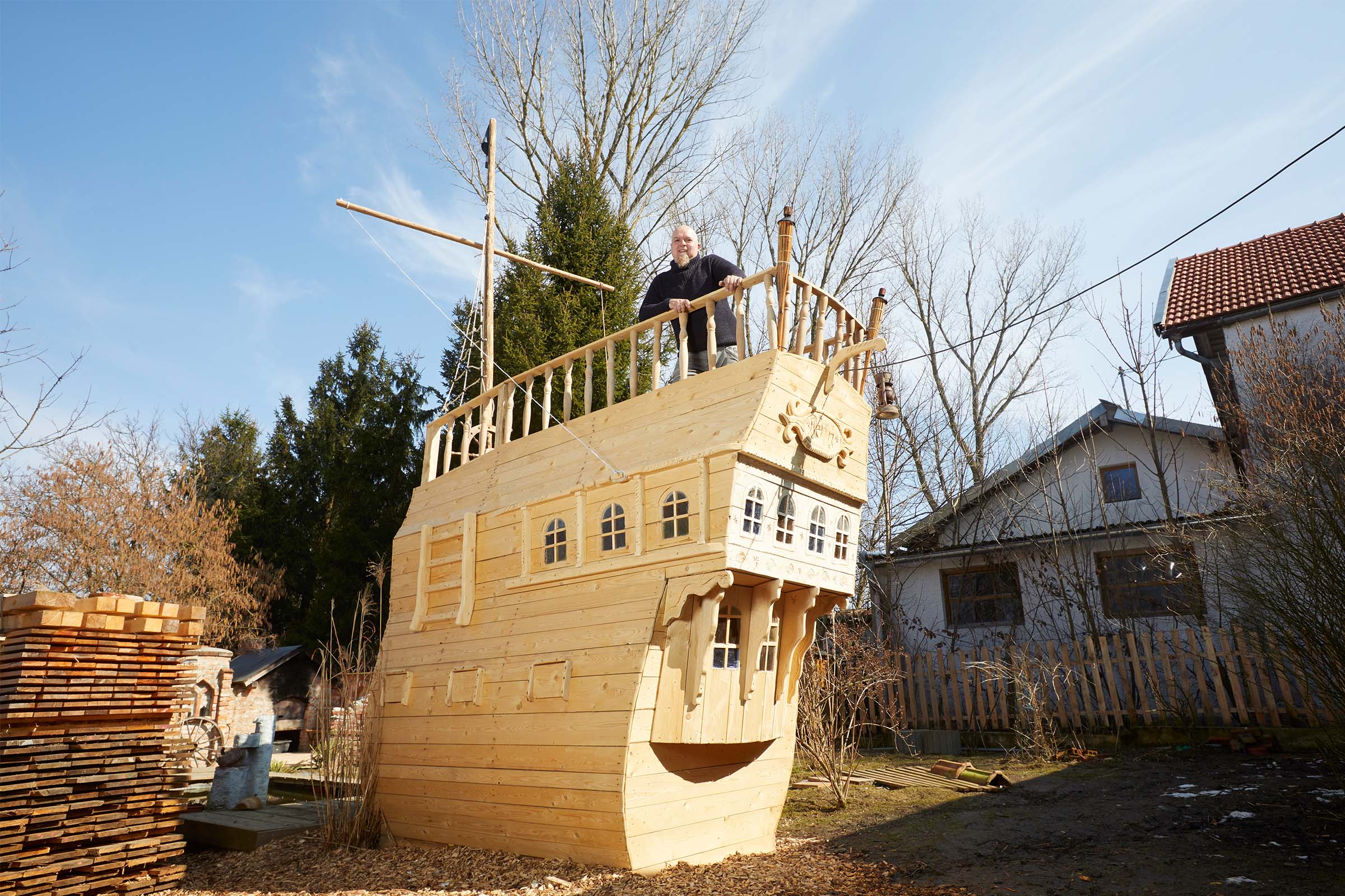 Grand bateau de jeu en bois avec un homme sur le pont à l'extérieur.
