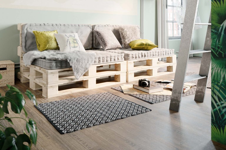 Wohnzimmer mit Palettensofa, Teppich und Leiterregal