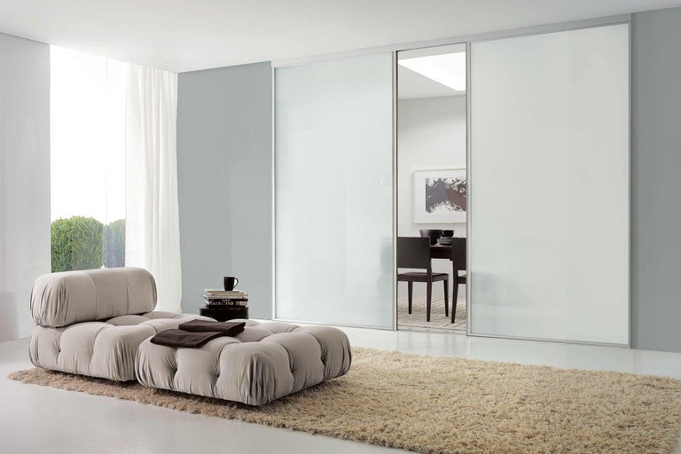 Intérieur avec armoire à portes coulissantes, fauteuil et tapis