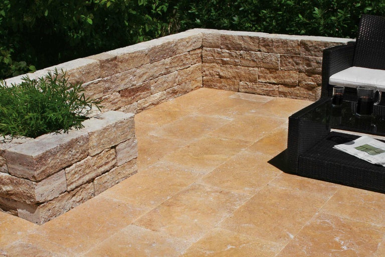 Terrasse avec mur en pierre naturelle, dalles de sol et coin salon