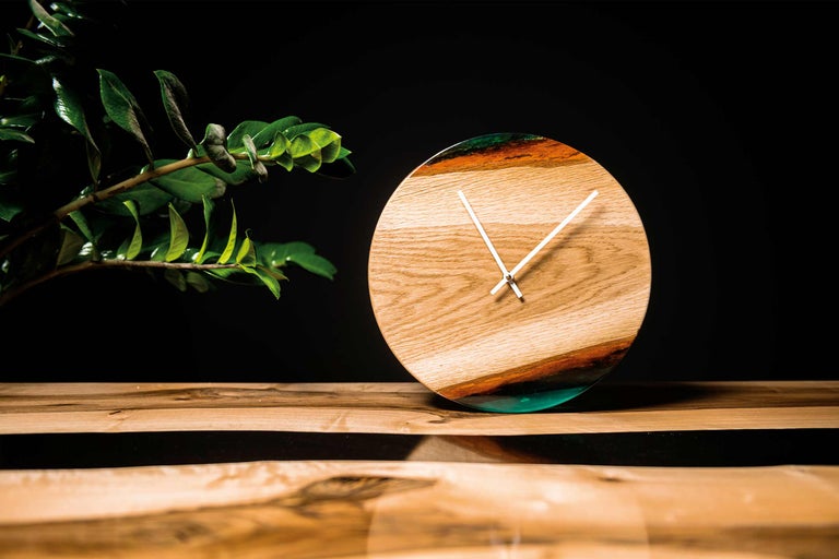 Horloge ronde en bois avec élément en résine sur table en bois