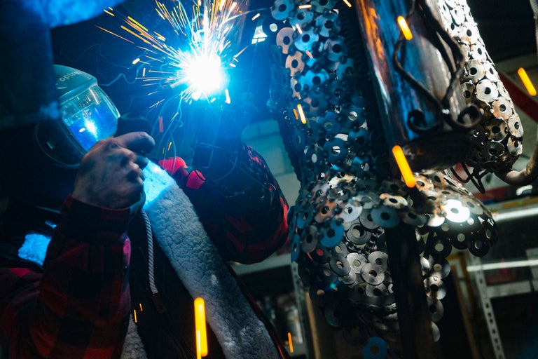 Soudeur travaillant sur une sculpture en métal