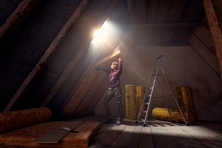 Grenier avec femme, laine d'isolation, échelle en aluminium et fenêtre de toit
