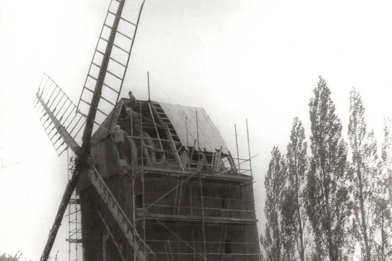 Moulin à vent en réparation avec échafaudage et artisans