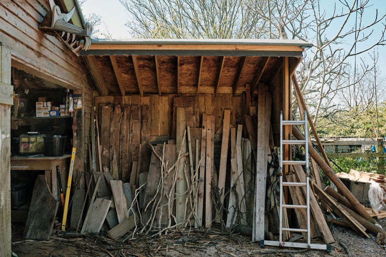 Abri en bois avec bois, échelle et outils