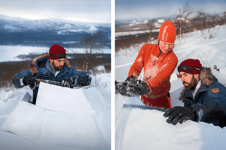 Deux personnes construisent un igloo avec une scie à neige dans un paysage enneigé.