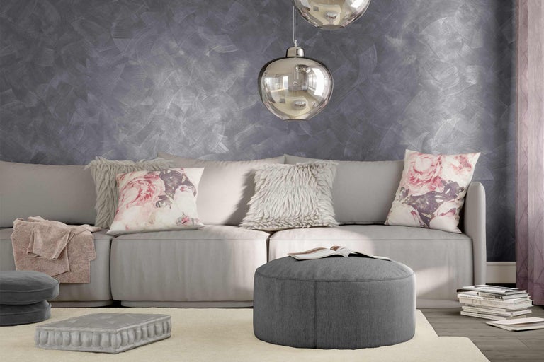 Salon lumineux avec canapé, coussins, tabouret et décoration