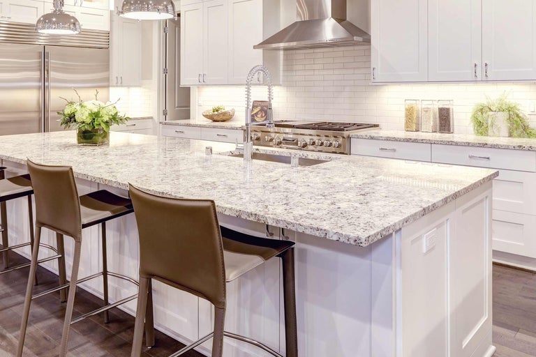 Cuisine claire avec îlot de cuisine, tabourets de bar et appareils en acier inoxydable