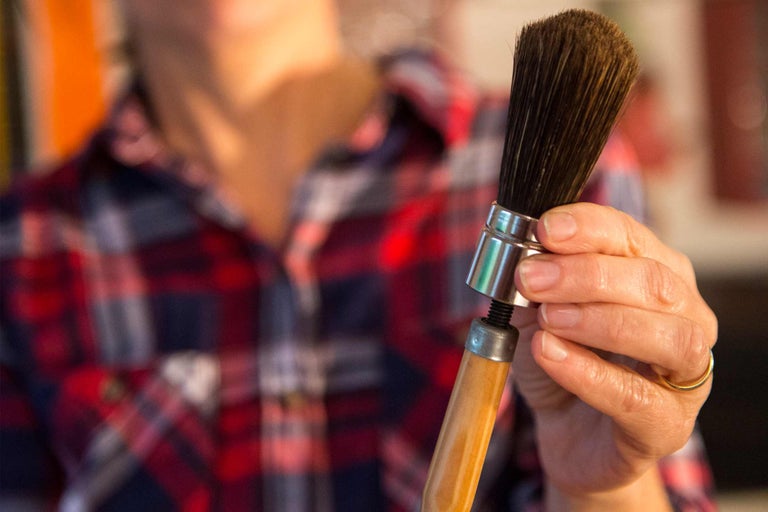 Pinceau rond avec manche en bois dans la main
