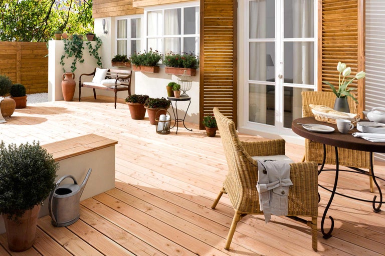 Terrasse avec planches en bois, mobilier de jardin et plantations