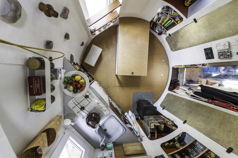 Innenansicht eines kleinen Hauses mit Küche, Tisch und Stauraum