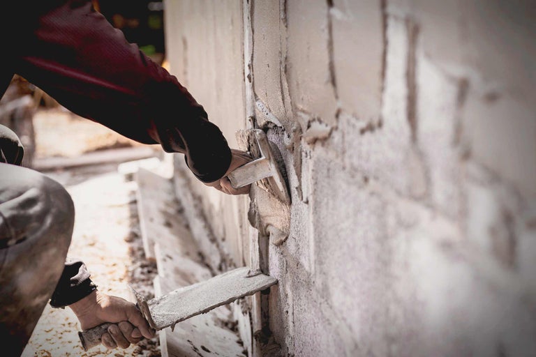 Handwerker verputzt eine Wand mit einer Kelle