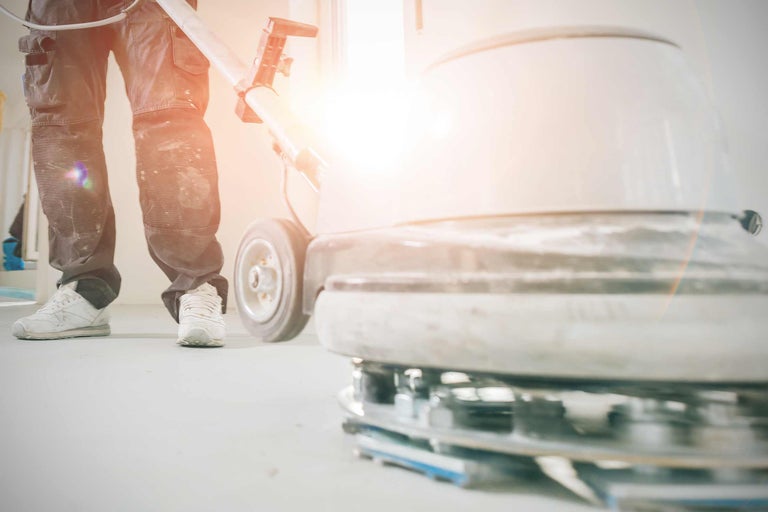 Un homme utilise une monobrosse pour le traitement des sols.