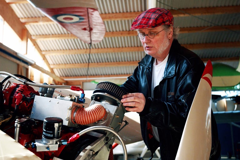 Mann repariert Flugzeugmotor in einer Werkstatt.