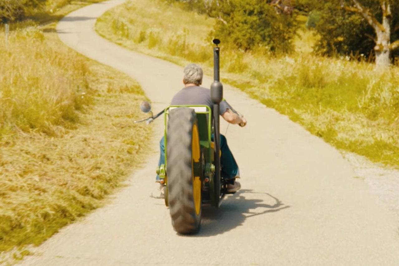 Tracteur sur une route de campagne, photographié de derrière.