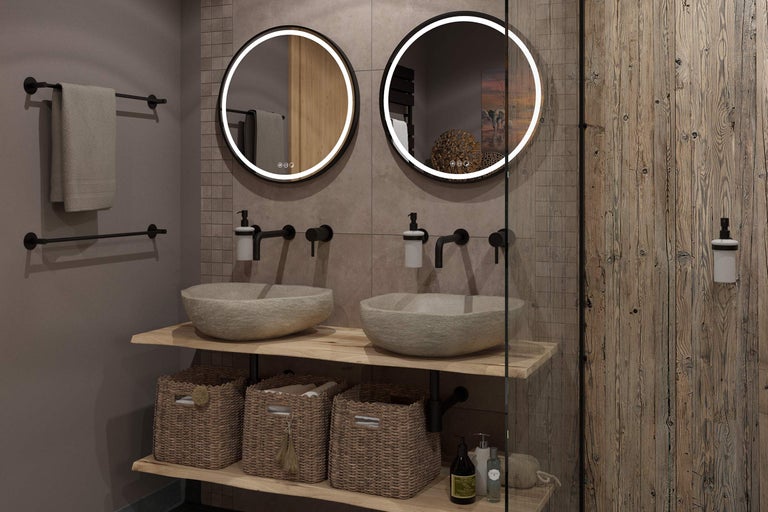 Modernes Badezimmer mit zwei runden LED-Spiegeln, Naturstein-Waschschalen auf Holzplatte, schwarzen Armaturen und geflochtenen Körben.