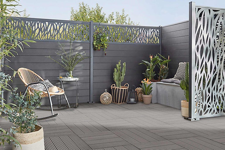 Espace extérieur aménagé avec brise-vue, mobilier de jardin et dalles de sol