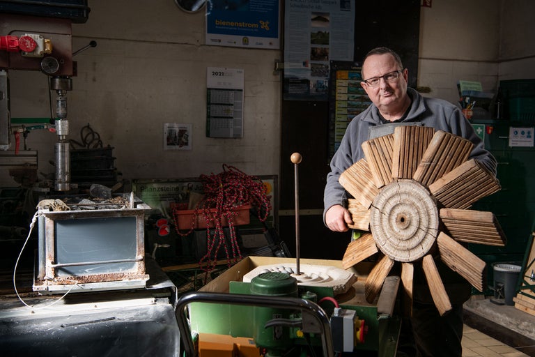 Artisan tenant une fleur en bois dans l'atelier