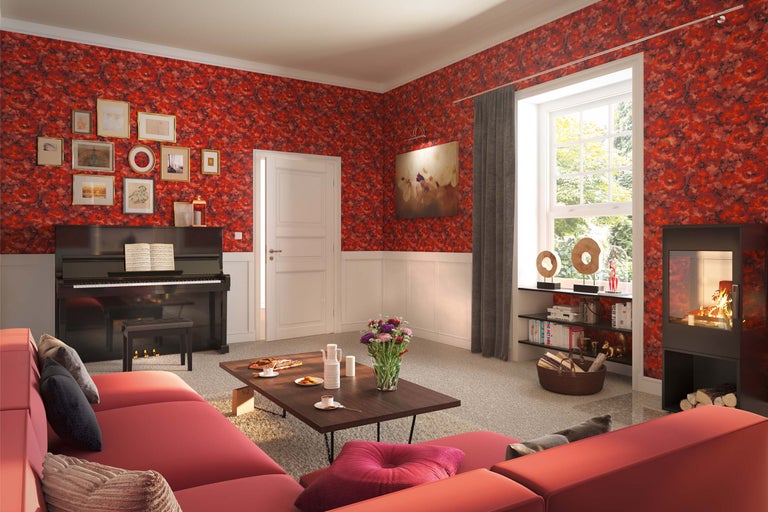 Salon avec papier peint à fleurs rouge, canapé, piano et cheminée