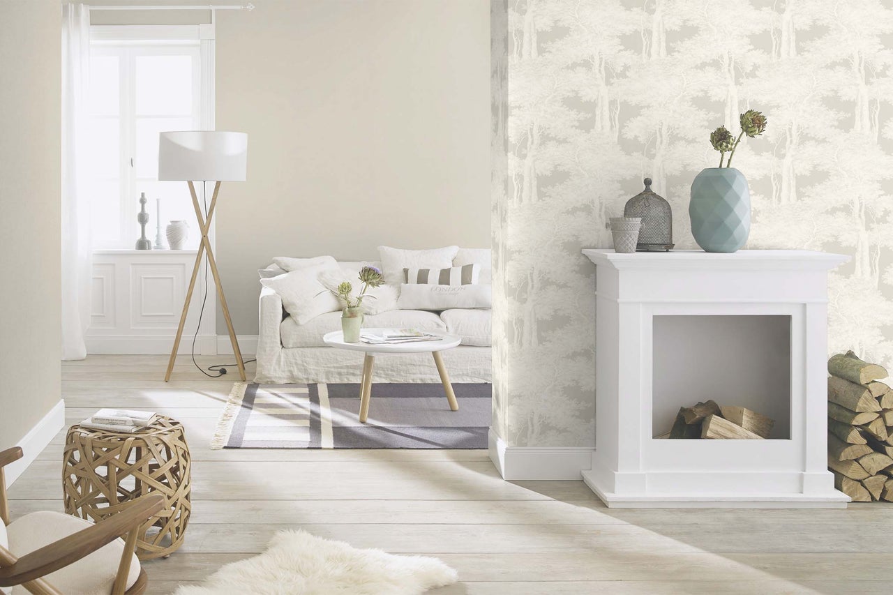 Salon avec canapé, table, lampadaire, cheminée et papier peint à motif de forêt