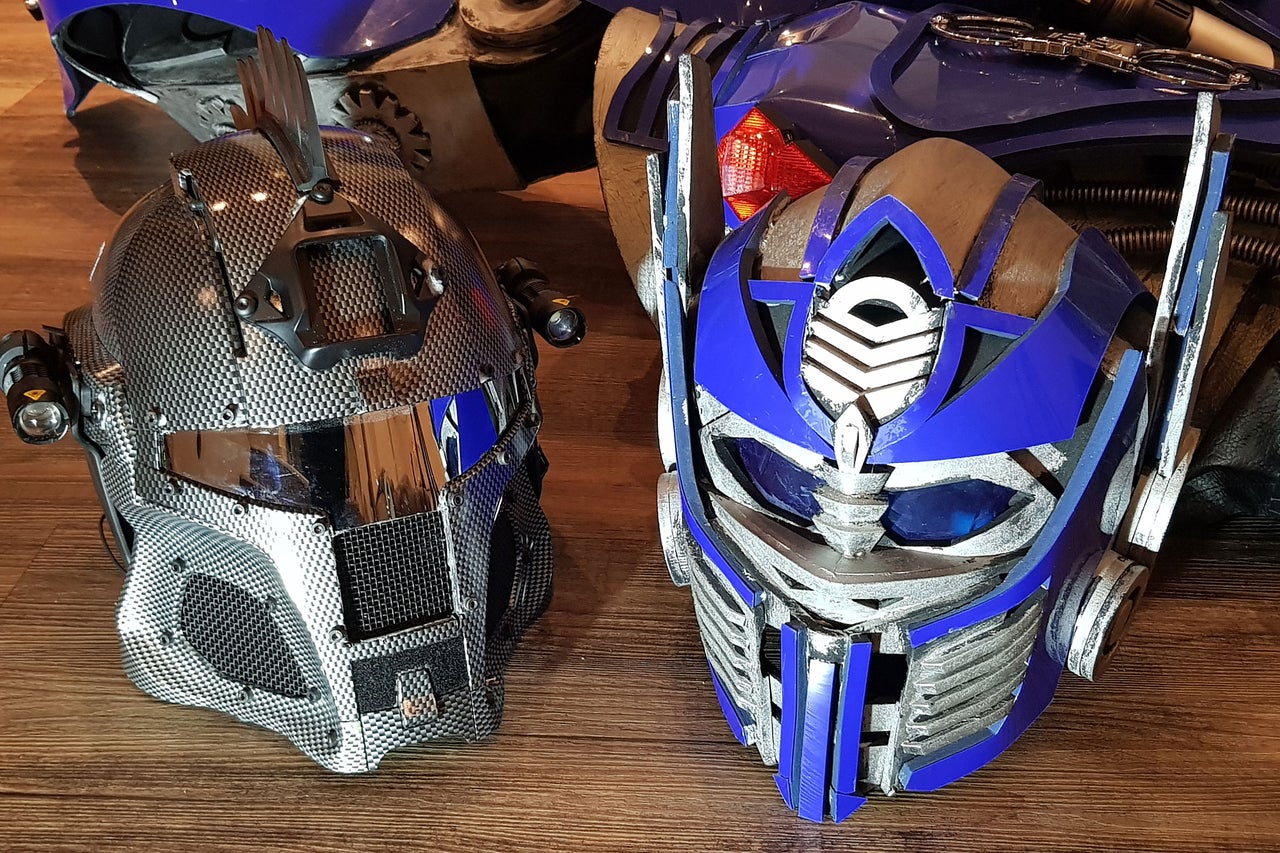 Deux casques Transformers sur un plancher en bois