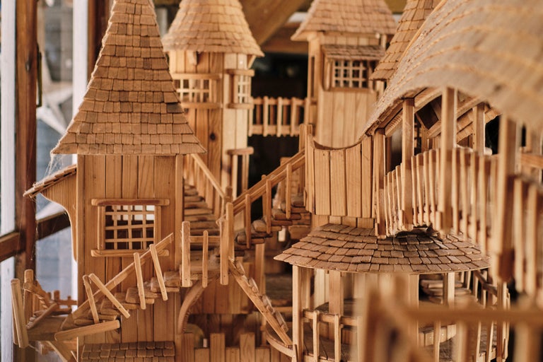 Maison de jeu en bois avec plusieurs étages, escaliers et toits