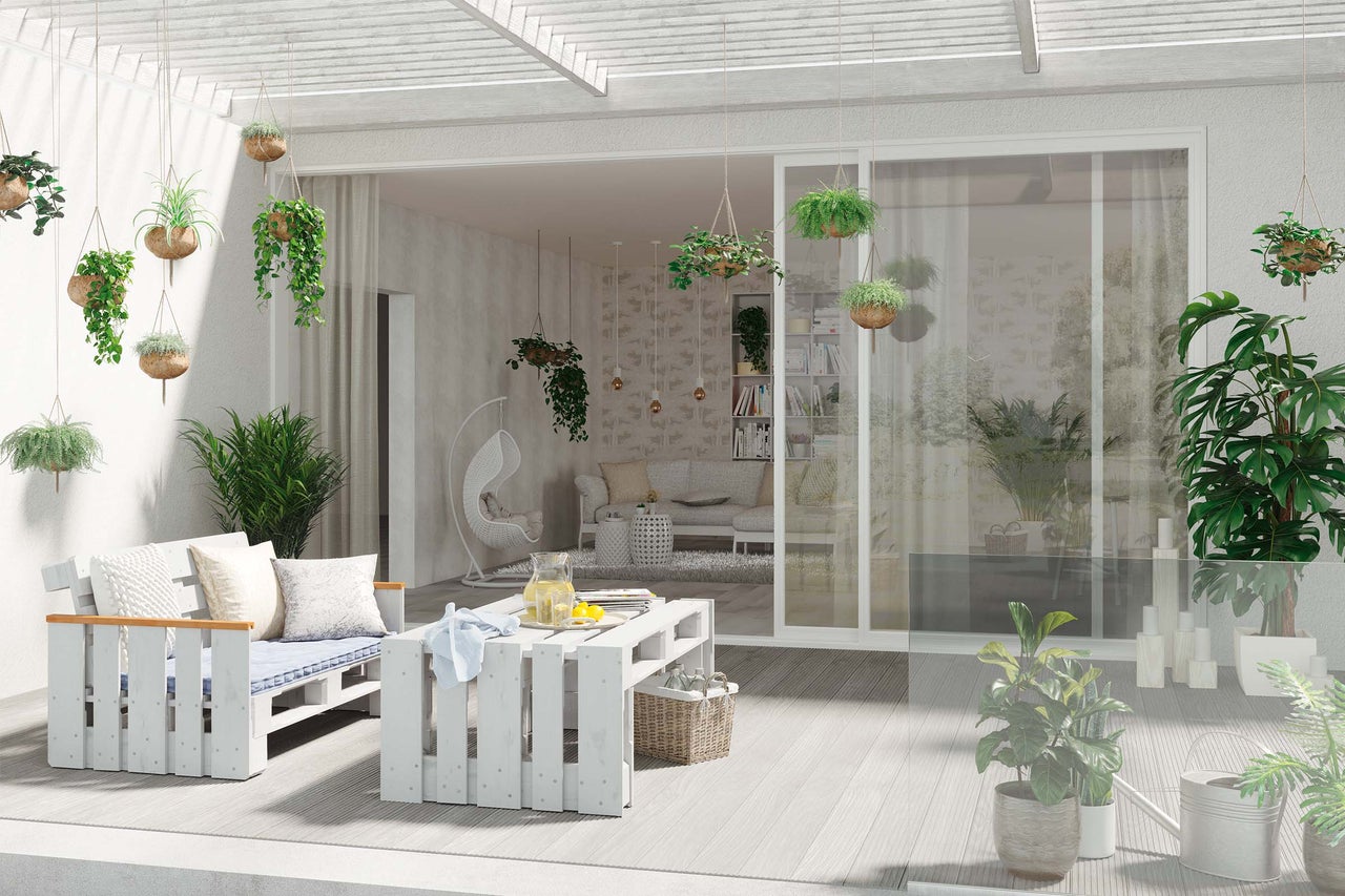 Terrasse lumineuse avec meubles en bois, plantes suspendues et aménagement extérieur confortable