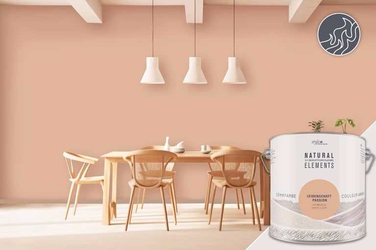 Salle à manger lumineuse avec table en bois, chaises et un seau de peinture murale Natural Elements Leidenschaft Terrakotta