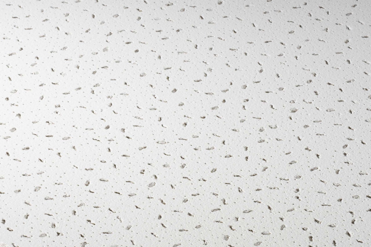 Gros plan d'un plafond acoustique avec des trous pour l'absorption acoustique