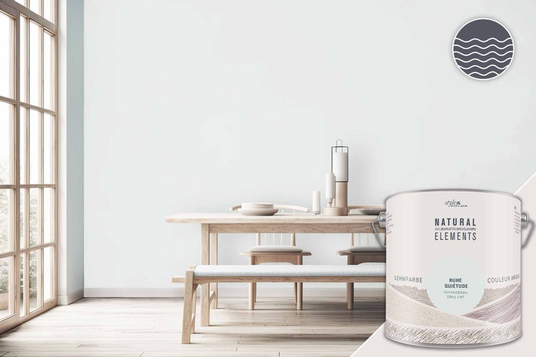 Scène de pièce lumineuse et conviviale avec table et chaises ainsi qu'un seau de peinture à l'argile