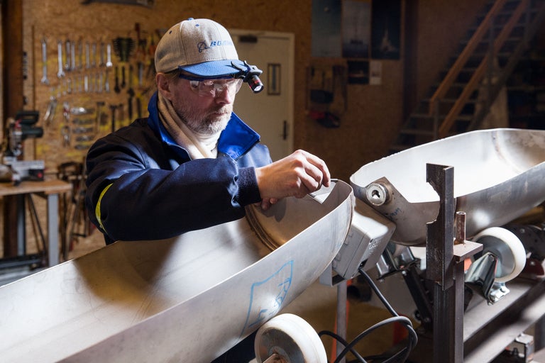 Un homme travaille sur un objet métallique dans un atelier