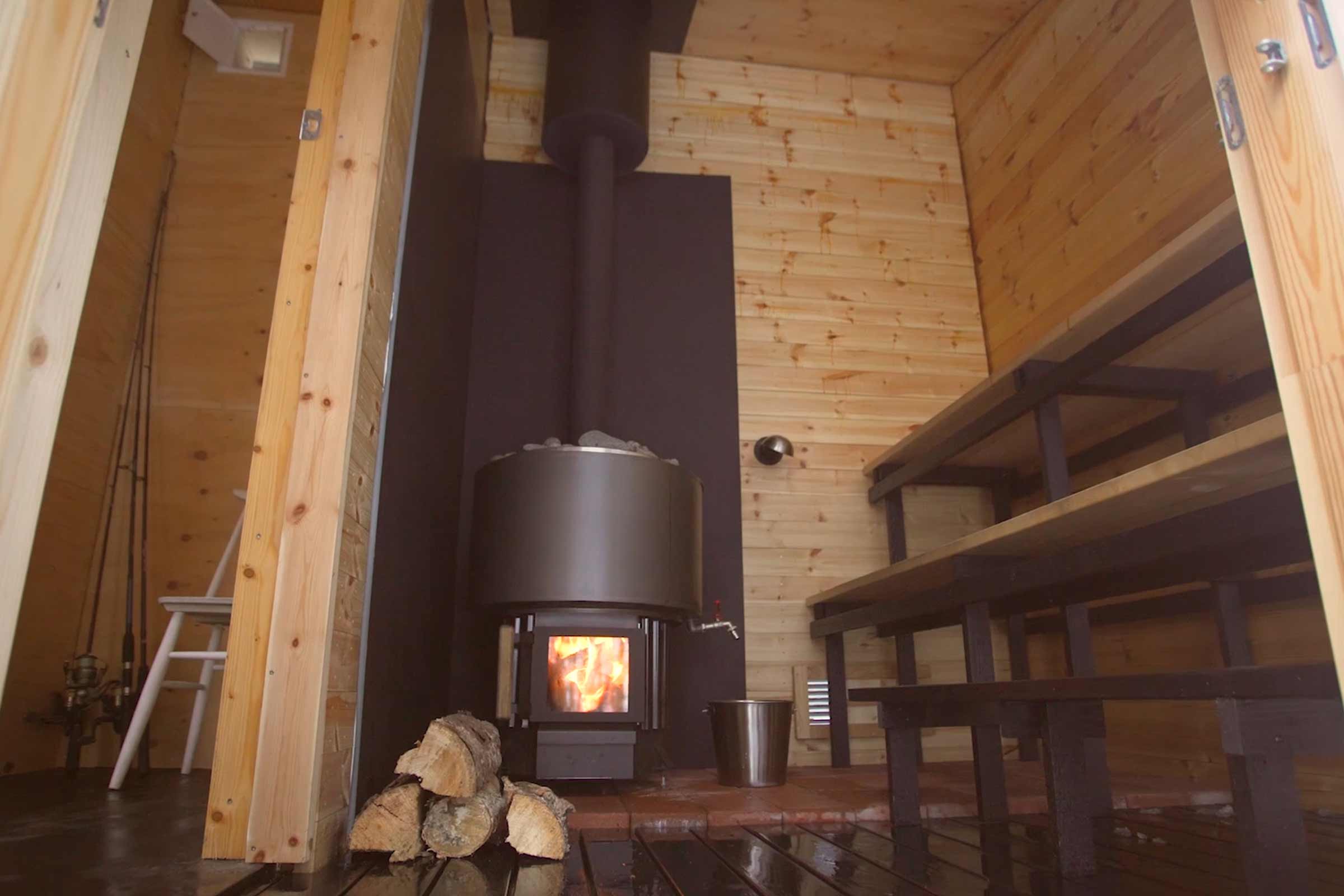 Sauna en bois avec poêle à bois et bancs de sauna