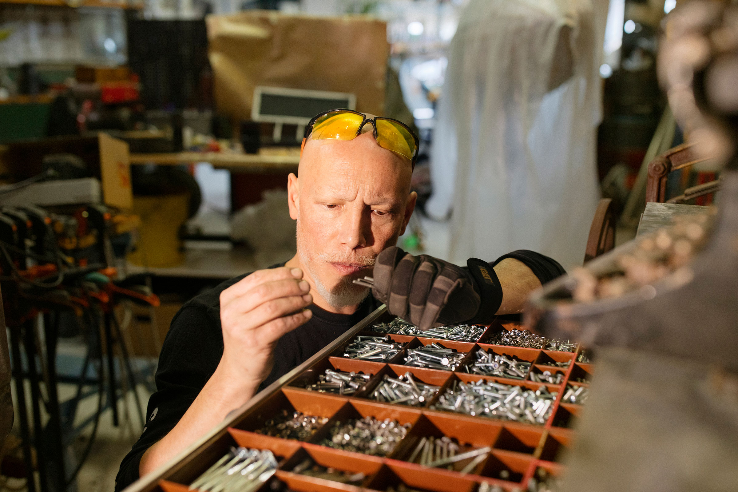 Artisan triant des vis dans une boîte de rangement