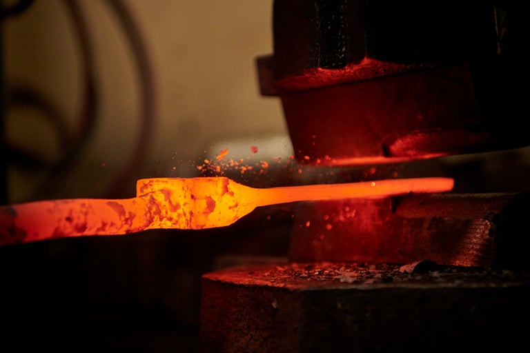 Pièce de métal incandescente dans une presse de forge