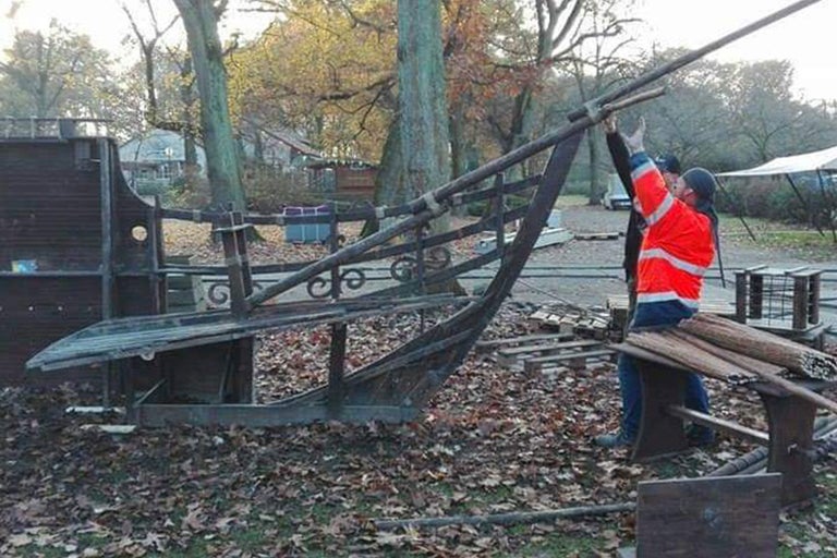 Unfertiger Spielplatz mit hölzernem Schiff und Bauarbeitern im Freien