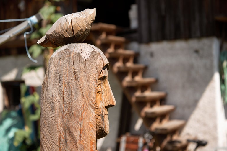 Sculpture en bois d'une tête avec un oiseau