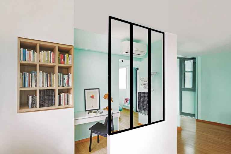 Pièce lumineuse avec bibliothèque, bureau et séparation de pièce en verre