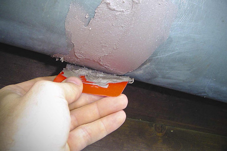 Application de mastic d'étanchéité à l'aide d'une spatule sur un tube