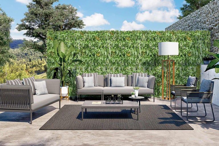 Terrasse avec canapé, fauteuils, table, tapis et mur végétal