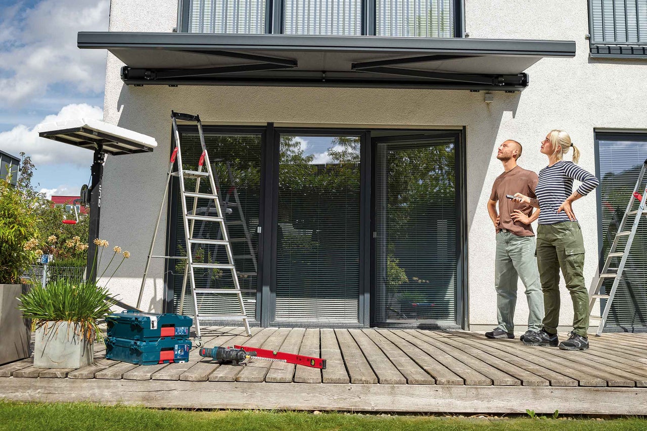 Terrasse mit Holzboden, Holztisch mit zwei Stühlen, Bambus und Sonnensegel