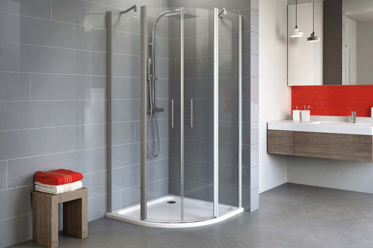 Eckdusche mit Duschwanne in modernem Badezimmer mit Waschbeckenunterschrank und Handtüchern