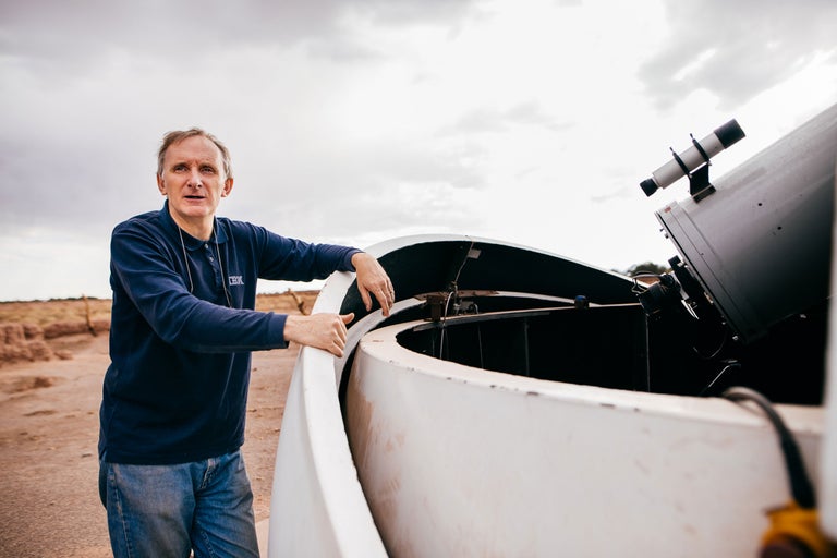 Mann neben Teleskop zur Sternenbeobachtung