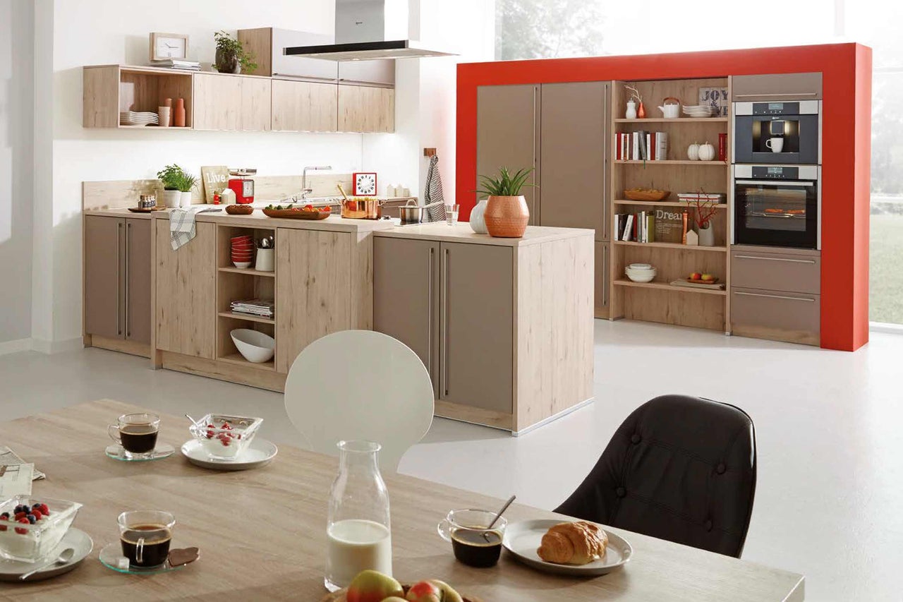 Cuisine claire et moderne avec îlot de cuisine, placards intégrés, étagères et table à manger.