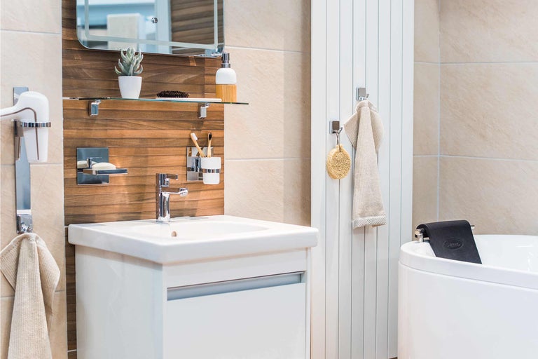 Salle de bains lumineuse avec lavabo, miroir, sèche-serviettes et baignoire.