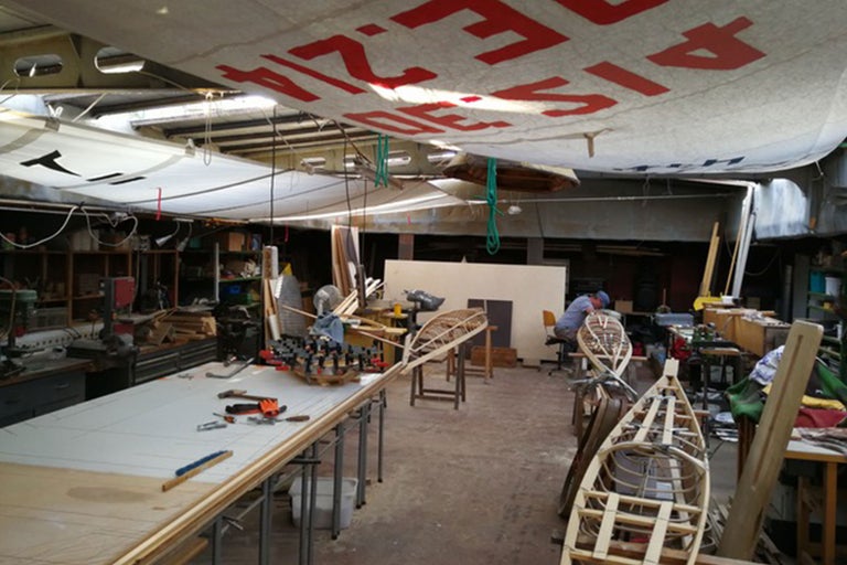 Atelier avec projets de bateaux en bois, outils et établi