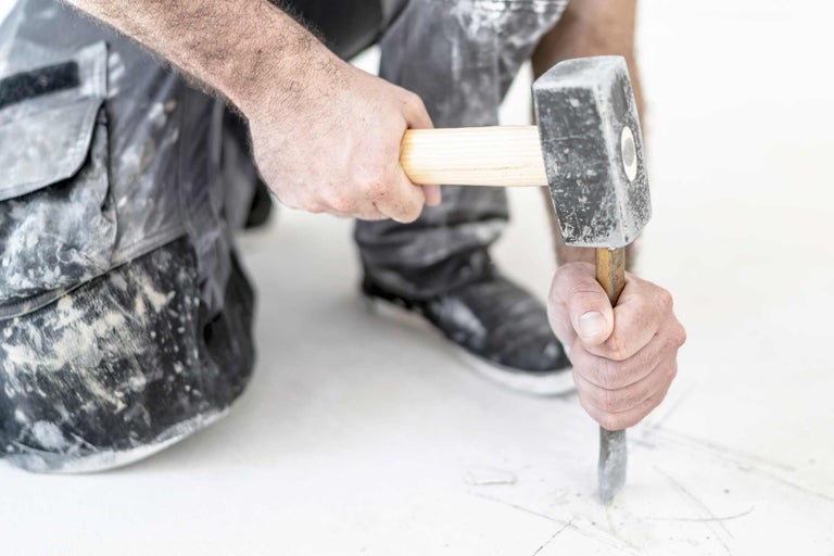 Artisan travaille le sol avec un marteau et un burin