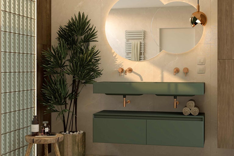 Salle de bains moderne avec lavabos verts, miroirs ronds avec éclairage et éléments décoratifs tels qu'une plante d'intérieur et des serviettes