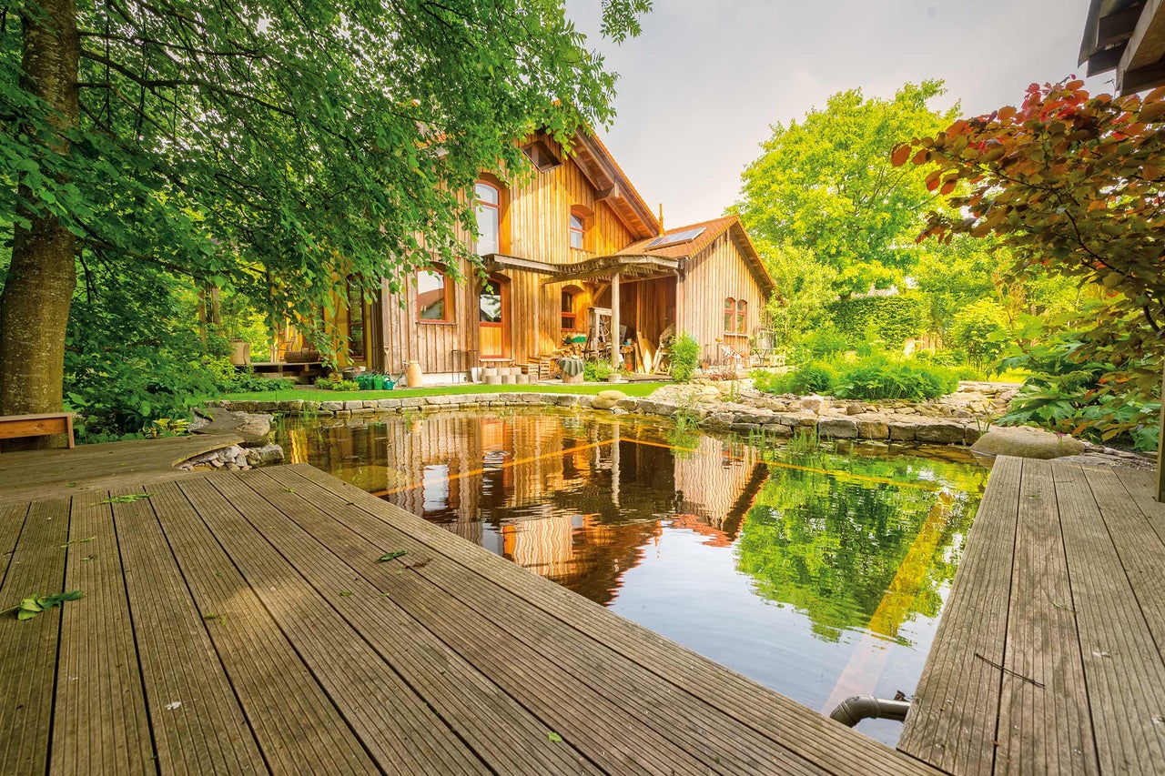 Maison en bois avec bassin de jardin et terrasse en bois