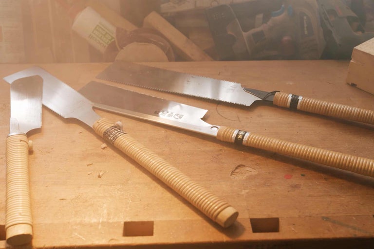 Diverses scies à main sur une surface en bois