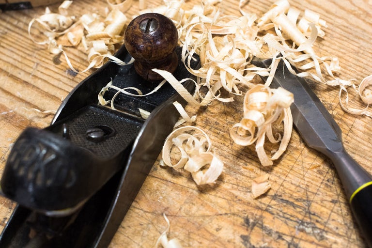 Hobel und Stecheisen mit Holzspänen auf einer Holzoberfläche